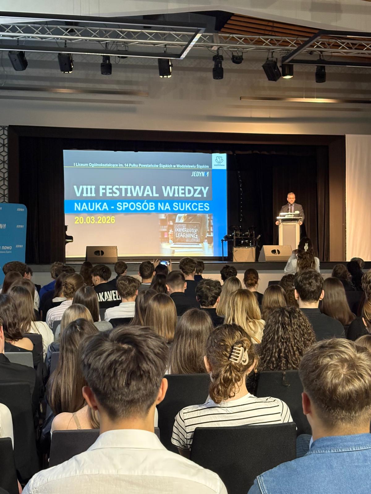 Osoba daje wykład w sali wykładowej